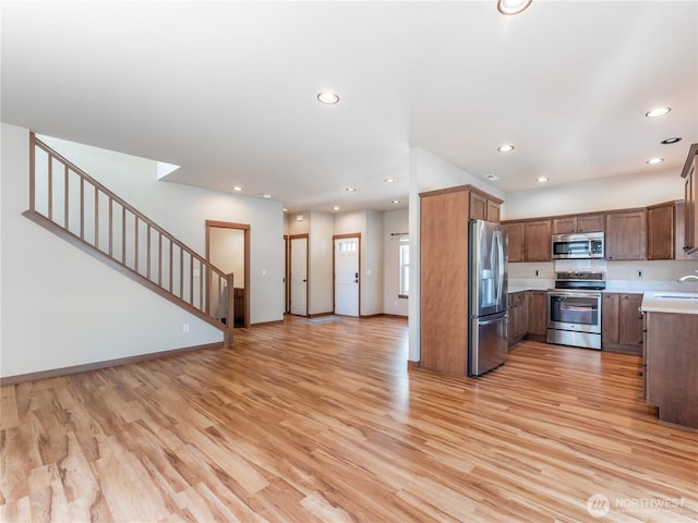 2452 NW Columbia Ave Unit 25, East Wenatchee, WA 98802 - kitchen featuring stainless steel appliances, a sink, light countertops, light wood finished floors, and open floor plan