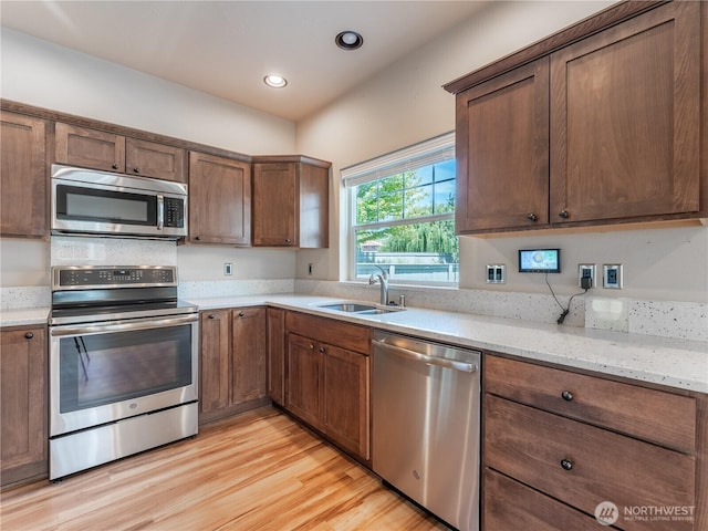 2452 NW Columbia Ave Unit 25, East Wenatchee, WA 98802 - kitchen with appliances with stainless steel finishes, a sink, light wood-style floors, light stone counters, and recessed lighting