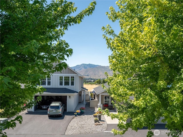 2452 NW Columbia Ave Unit 25, East Wenatchee, WA 98802 - view of front of property featuring board and batten siding, asphalt driveway, a mountain view, and a garage