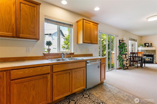 4155 Aurora Loop, Bellingham, WA 98226 - kitchen with stainless steel dishwasher, light countertops, brown cabinets, a glass covered fireplace, and carpet floors