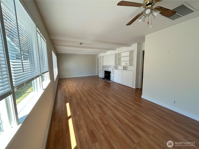425 Henry St, Shelton, WA 98584 - unfurnished living room with baseboards, a ceiling fan, wood finished floors, a tile fireplace, and beam ceiling
