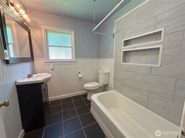 425 Henry St, Shelton, WA 98584 - bathroom with tile patterned floors, a wainscoted wall, vanity, toilet, and bathtub / shower combination