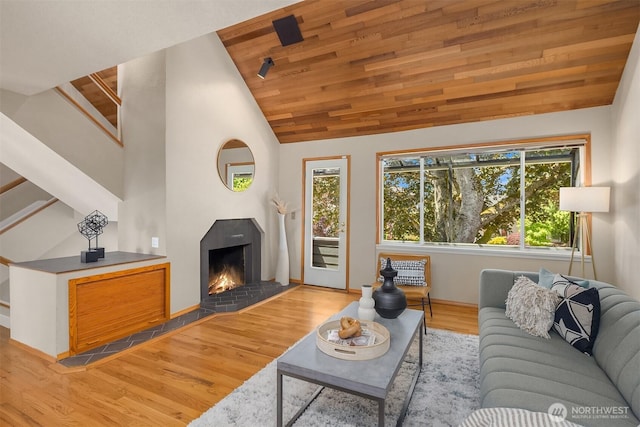 4142 52nd Ave SW, Seattle, WA 98116 - living room featuring healthy amount of natural light, wood finished floors, stairs, a lit fireplace, and wood ceiling
