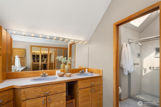 4142 52nd Ave SW, Seattle, WA 98116 - bathroom featuring lofted ceiling, a skylight, double vanity, a stall shower, and tile patterned floors
