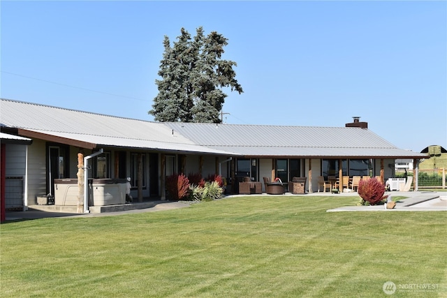 8708 Rd K Rd NE, Moses Lake, WA 98837 - back of property featuring a chimney, a lawn, metal roof, and a patio area