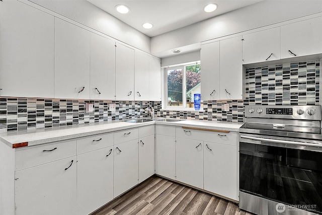 405 Calistoga St W, Orting, WA 98360 - kitchen featuring stainless steel range with electric stovetop, light countertops, a sink, wood finished floors, and white cabinets