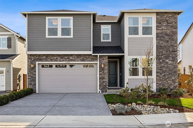 13920 181st St E Unit 64, Puyallup, WA 98374 - view of front of property with stone siding, driveway, and a garage