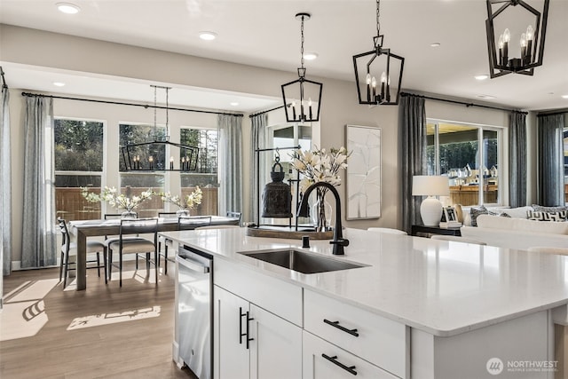 13920 181st St E Unit 64, Puyallup, WA 98374 - kitchen featuring a sink, a chandelier, dishwasher, an island with sink, and light stone countertops