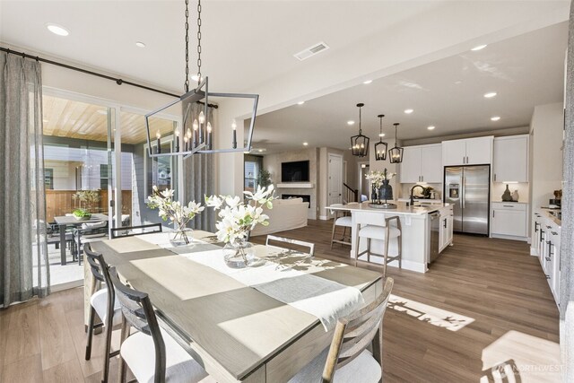 13920 181st St E Unit 64, Puyallup, WA 98374 - dining room with light wood-type flooring, a chandelier, recessed lighting, and a fireplace