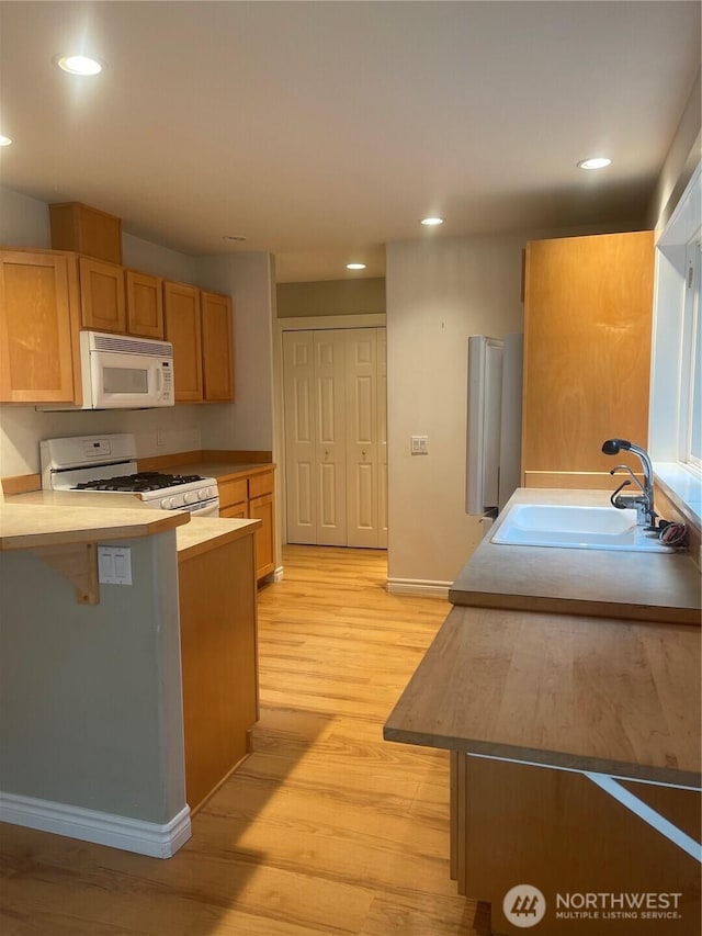 528 Chinook Way, Friday Harbor, WA 98250 - kitchen featuring white appliances, light wood-type flooring, recessed lighting, light countertops, and a peninsula