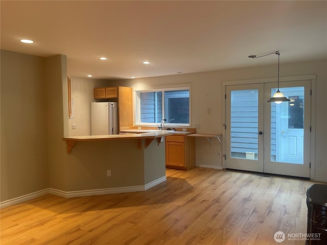 528 Chinook Way, Friday Harbor, WA 98250 - kitchen featuring freestanding refrigerator, light wood-style flooring, a breakfast bar, recessed lighting, and a peninsula