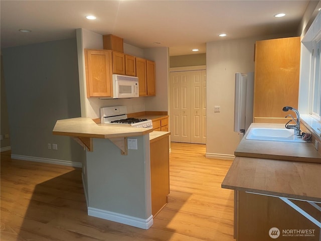 528 Chinook Way, Friday Harbor, WA 98250 - kitchen featuring white appliances, a peninsula, light wood-type flooring, a breakfast bar, and recessed lighting