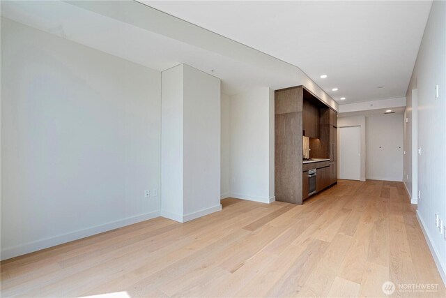 121 Stewart St Unit 3004, Seattle, WA 98101 - unfurnished living room with light wood finished floors, recessed lighting, and baseboards