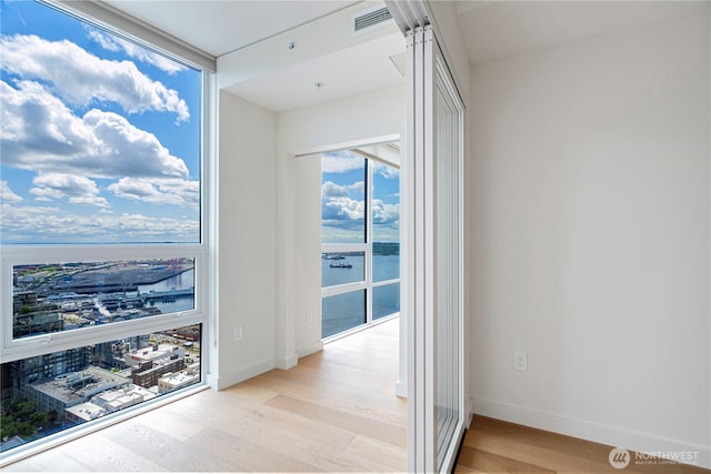 121 Stewart St Unit 3004, Seattle, WA 98101 - hallway featuring light wood-style floors, a water view, and baseboards