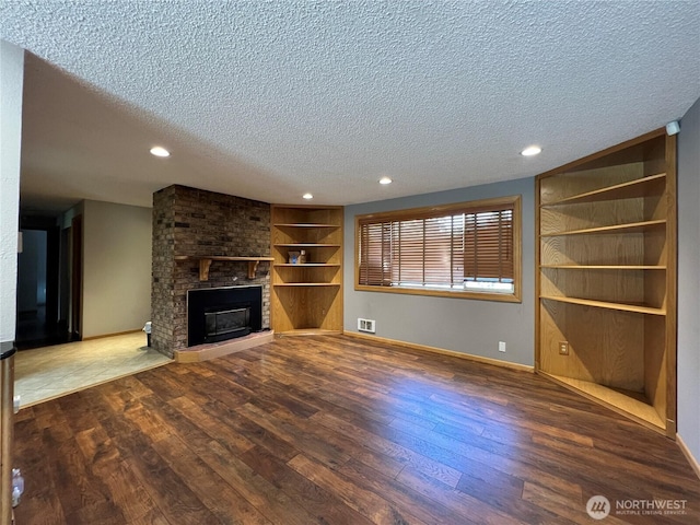 2116 E 65th St, Tacoma, WA 98404 - unfurnished living room with a textured ceiling, wood finished floors, built in features, baseboards, and recessed lighting