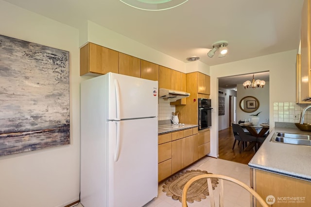 7924 S 112th St, Seattle, WA 98178 - kitchen with freestanding refrigerator, a sink, oven, under cabinet range hood, and tasteful backsplash