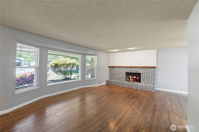 28713 SE 462nd Pl, Enumclaw, WA 98022 - unfurnished living room with dark wood-type flooring, plenty of natural light, a textured ceiling, baseboards, and a fireplace