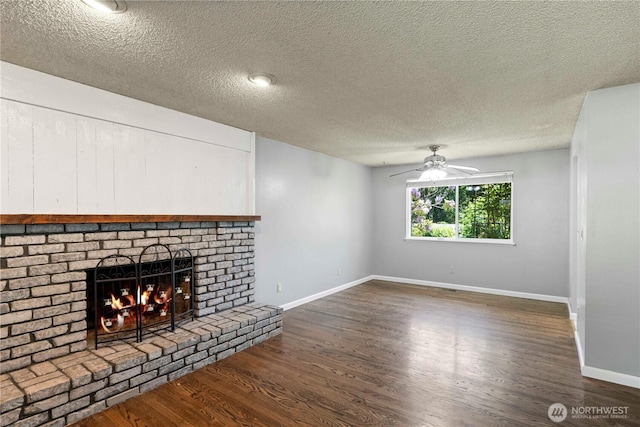 28713 SE 462nd Pl, Enumclaw, WA 98022 - unfurnished living room featuring ceiling fan, dark wood-type flooring, baseboards, a textured ceiling, and a brick fireplace