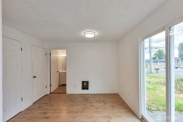 1702 C St SE, Auburn, WA 98002 - unfurnished bedroom featuring light wood-type flooring, a textured ceiling, and ensuite bathroom