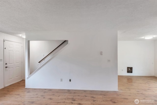 1702 C St SE, Auburn, WA 98002 - empty room with light wood-style floors and a textured ceiling