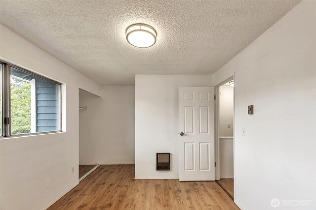 1702 C St SE, Auburn, WA 98002 - empty room with a textured ceiling, wood finished floors, and baseboards