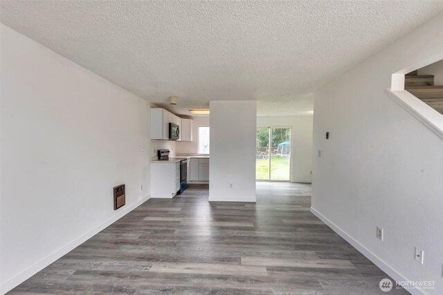 1702 C St SE, Auburn, WA 98002 - unfurnished living room with a textured ceiling, dark wood-style floors, baseboards, and stairway
