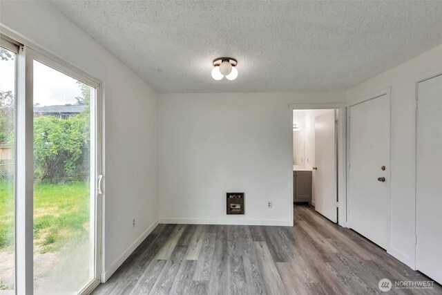 1702 C St SE, Auburn, WA 98002 - unfurnished bedroom with a textured ceiling, wood finished floors, ensuite bathroom, and baseboards