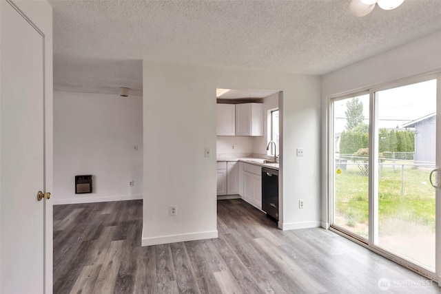 1702 C St SE, Auburn, WA 98002 - kitchen with a sink, a textured ceiling, dishwasher, white cabinetry, and wood finished floors
