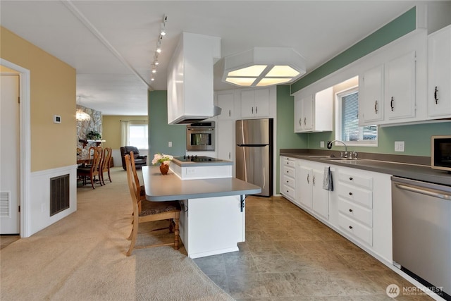 1402 22nd St NE Unit 47, Auburn, WA 98002 - kitchen featuring appliances with stainless steel finishes, a sink, white cabinetry, a breakfast bar area, and dark countertops