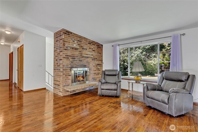 31006 38th Ave S, Auburn, WA 98001 - living room featuring wood finished floors, a brick fireplace, and baseboards