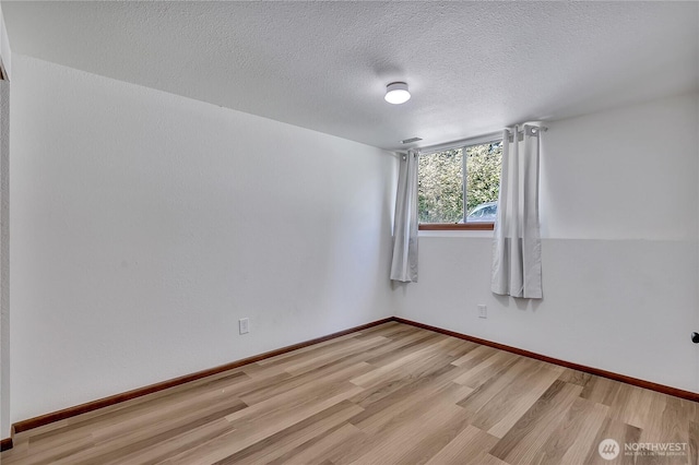 31006 38th Ave S, Auburn, WA 98001 - spare room with wood finished floors, a textured ceiling, and baseboards