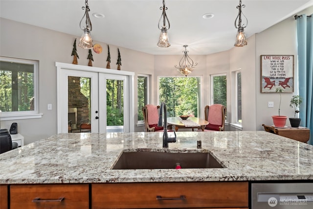 1566 Deer Ridge Rd, Oak Harbor, WA 98277 - kitchen featuring a sink, french doors, stainless steel dishwasher, light stone counters, and brown cabinets