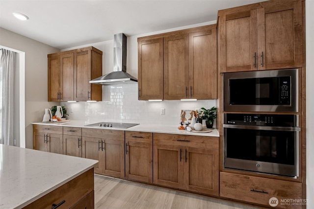 13912 181st St E Unit 62, Puyallup, WA 98374 - kitchen featuring appliances with stainless steel finishes, wall chimney exhaust hood, brown cabinetry, and backsplash