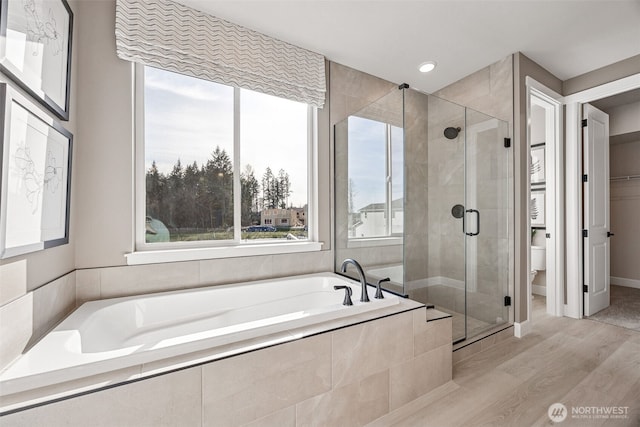13912 181st St E Unit 62, Puyallup, WA 98374 - bathroom with toilet, a garden tub, a shower stall, wood finished floors, and recessed lighting