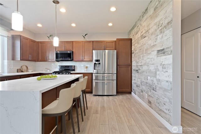 20325 90th Pl S, Kent, WA 98031 - kitchen featuring stainless steel appliances, recessed lighting, hanging light fixtures, a breakfast bar area, and light wood-style flooring