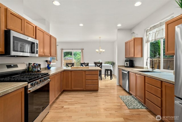 1082 G St SW, Tumwater, WA 98512 - kitchen featuring appliances with stainless steel finishes, a peninsula, a sink, light wood-type flooring, and recessed lighting
