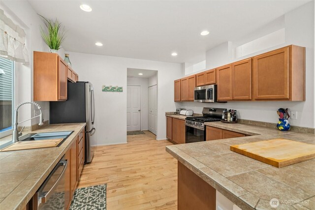 1082 G St SW, Tumwater, WA 98512 - kitchen featuring appliances with stainless steel finishes, a sink, light wood-style floors, recessed lighting, and brown cabinets