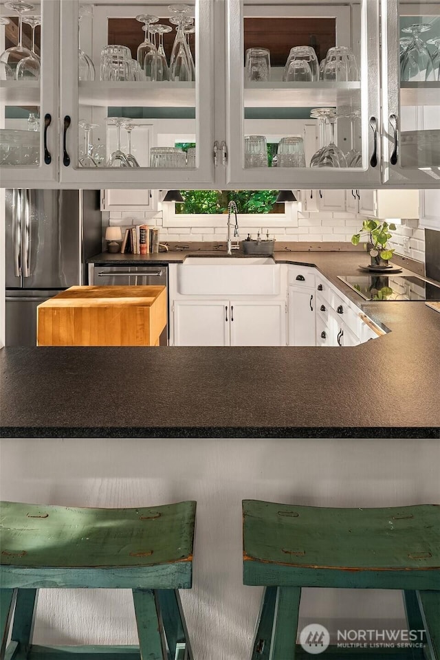 27603 145th Ave SW, Vashon, WA 98070 - kitchen with a sink, appliances with stainless steel finishes, white cabinets, and decorative backsplash