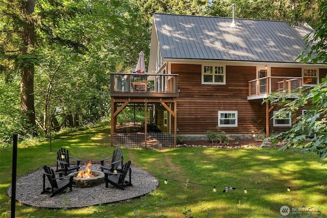 27603 145th Ave SW, Vashon, WA 98070 - back of property with an outdoor fire pit, a lawn, a wooden deck, metal roof, and stairs