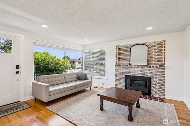 3007 23rd Ave S, Seattle, WA 98144 - living area featuring a textured ceiling, wood finished floors, healthy amount of natural light, a fireplace, and recessed lighting