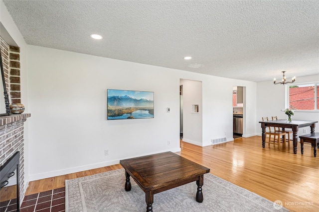 3007 23rd Ave S, Seattle, WA 98144 - living room with a fireplace, a chandelier, a textured ceiling, wood finished floors, and recessed lighting