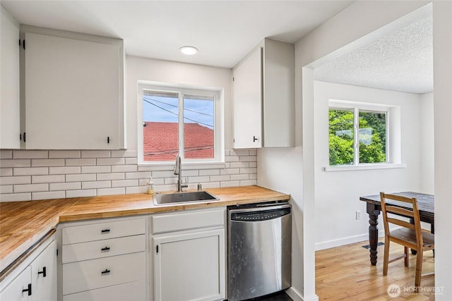 3007 23rd Ave S, Seattle, WA 98144 - kitchen with stainless steel dishwasher, wooden counters, tasteful backsplash, light wood finished floors, and white cabinetry