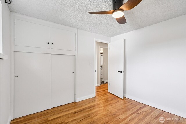 3007 23rd Ave S, Seattle, WA 98144 - unfurnished bedroom featuring a textured ceiling, light wood-type flooring, a closet, and a ceiling fan
