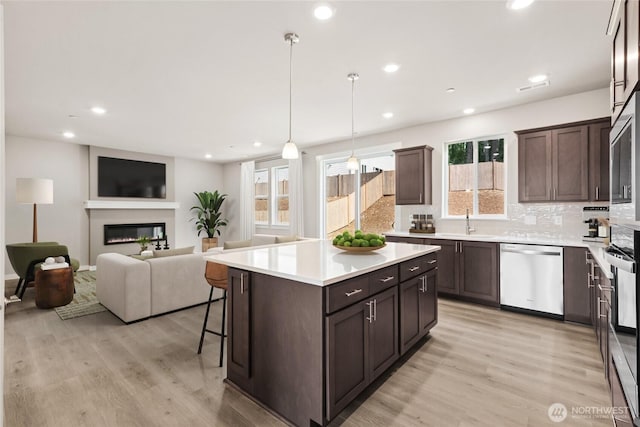 3704 98th Avenue Ct E Unit 1, Edgewood, WA 98371 - kitchen featuring dishwasher, dark brown cabinetry, light wood-style floors, backsplash, and recessed lighting
