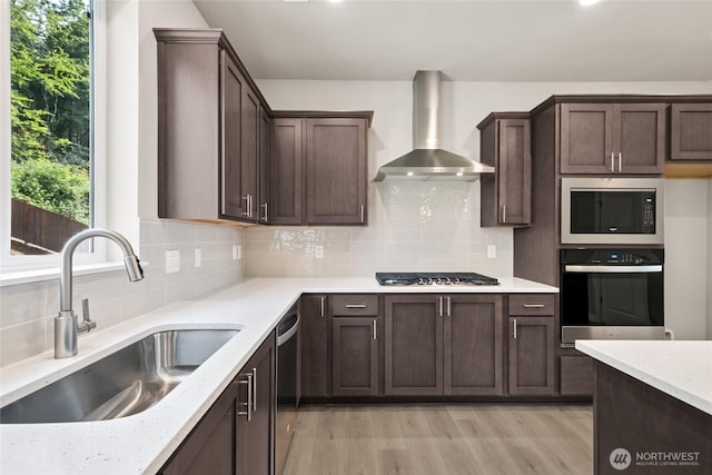3704 98th Avenue Ct E Unit 1, Edgewood, WA 98371 - kitchen with stainless steel appliances, wall chimney exhaust hood, light wood finished floors, dark brown cabinetry, and backsplash