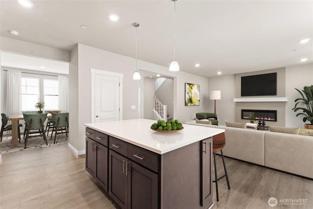 3704 98th Avenue Ct E Unit 1, Edgewood, WA 98371 - kitchen with light wood-type flooring, a kitchen bar, light countertops, recessed lighting, and a kitchen island