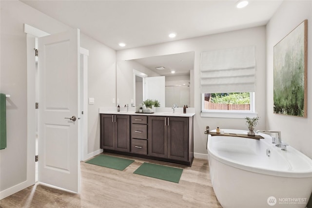 3704 98th Avenue Ct E Unit 1, Edgewood, WA 98371 - bathroom featuring a soaking tub, double vanity, wood finished floors, recessed lighting, and a stall shower