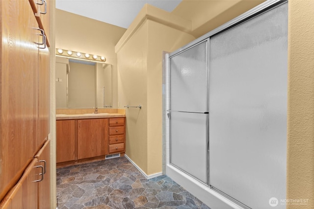 1933 Windflower Ln SE, Lacey, WA 98503 - full bath featuring vanity, a stall shower, stone finish floors, and baseboards