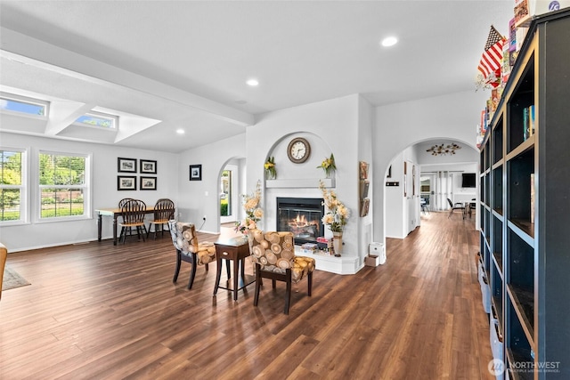 1933 Windflower Ln SE, Lacey, WA 98503 - dining area featuring arched walkways, a glass covered fireplace, wood finished floors, recessed lighting, and beamed ceiling