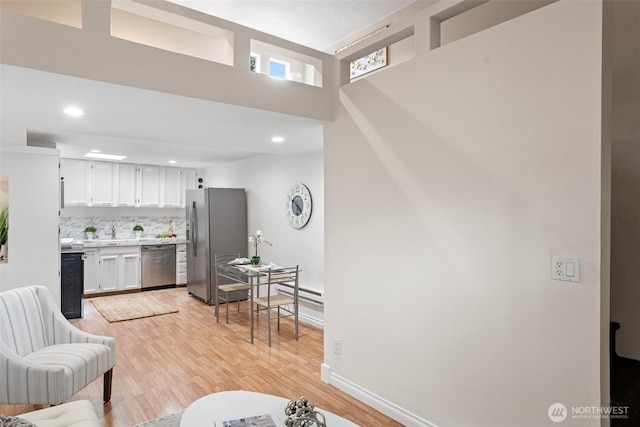14600 SE 176th St Unit H11, Renton, WA 98058 - living area with light wood-style flooring, a high ceiling, recessed lighting, baseboards, and baseboard heating